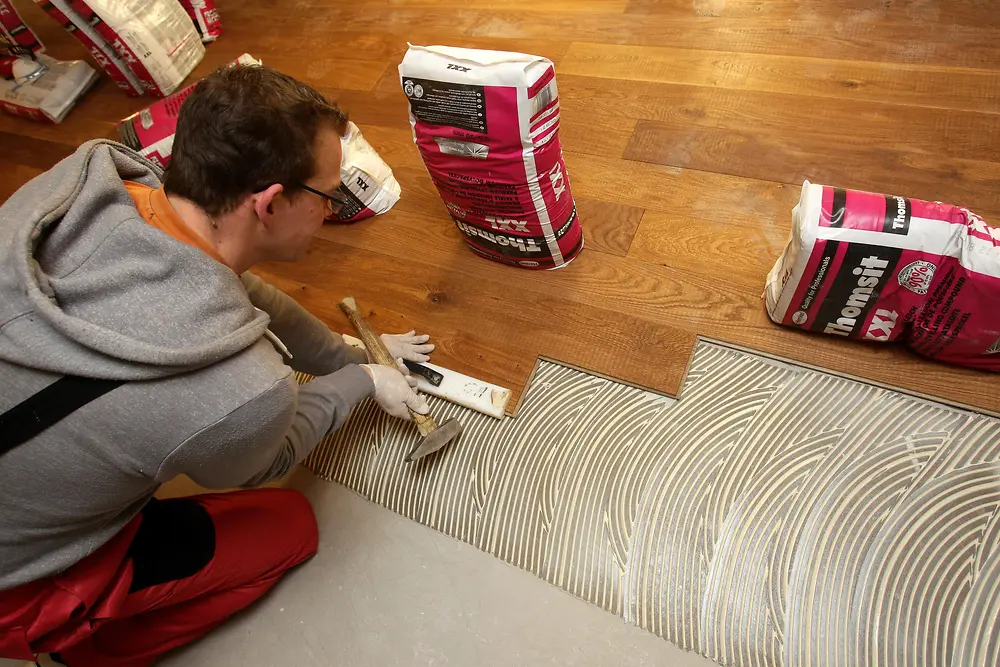 Im Klebstoffbett wird die zuletzt eingelegte Diele angeschlagen